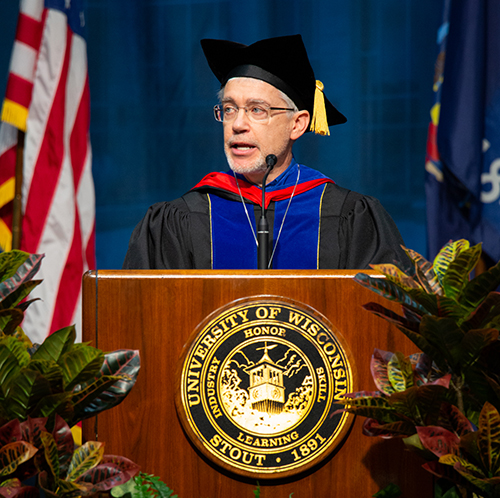Patrick Guilfoile addresses graduates during the first ceremony Saturday, Dec. 14, at Johnson Fieldhouse.