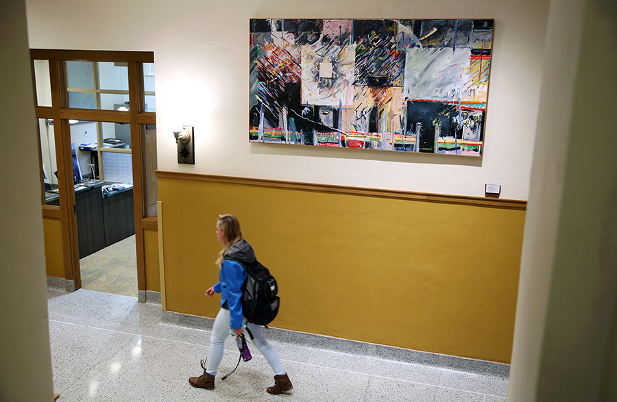 A student walks past artwork on the first floor of Harvey Hall at UW-Stout.