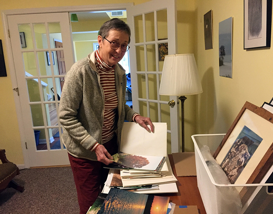 Mary Riordan looks through some of Dan Riordan’s photo prints that will be sold Dec. 11 to benefit the Bridge to Hope in Menomonie.
