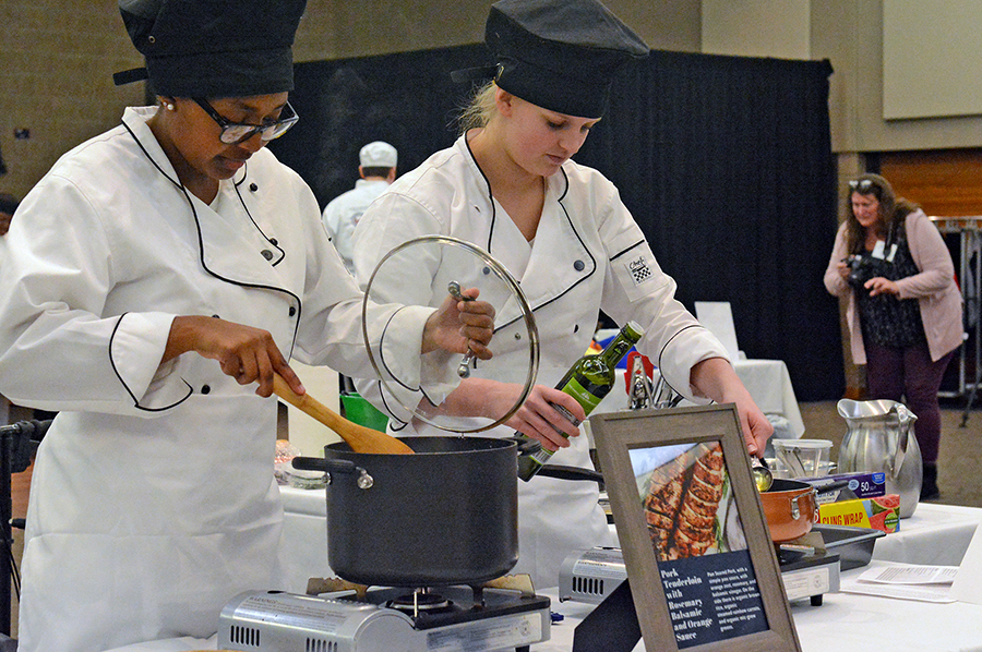 Amery High School students Mckenna Nelson, at left, and Reese Benware cook their pork tenderloin with balsamic sauce.
