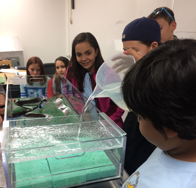 Students from the LCO Ojibwe school try an environmental science experiment in May while visiting UW-Stout.UW-Stout students, including Noelle Metoxen front left, in the Today and Beyond program gather in front of the LCO Ojibwe school in Hayward.