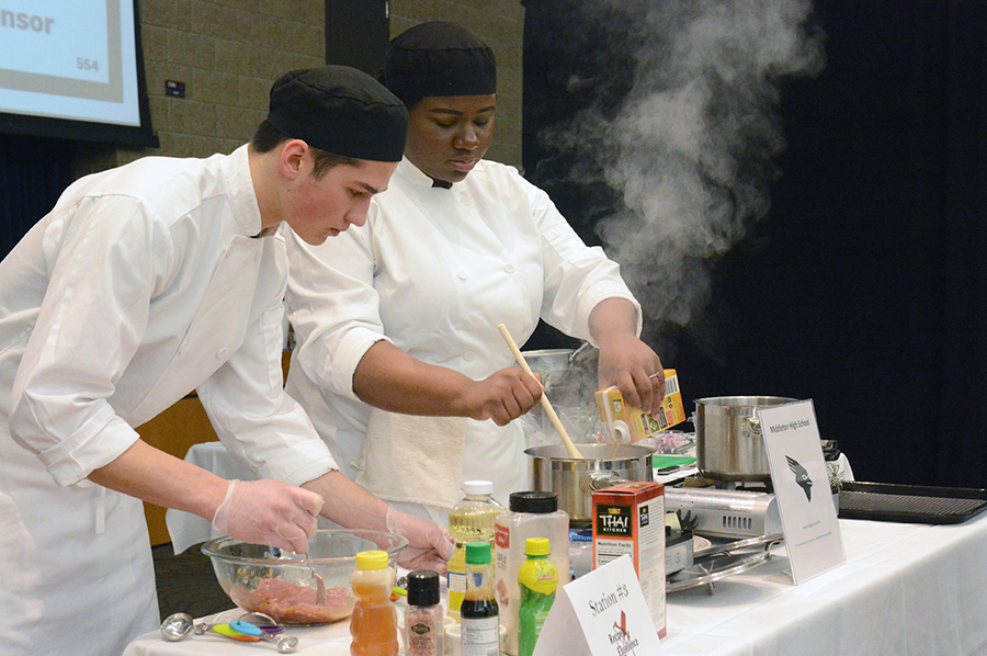 Middleton High School team members Hudson Roberts, at left, and Jade Davis, cook up a honey ginger pork pho dish during the competition.