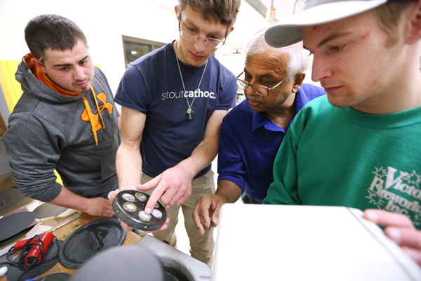 Rajiv Asthana works with students in a lab.