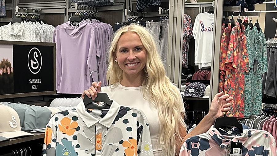 Jessica Cook looks at some of the Swannies Golf apparel she designed and which is on sale at a retail store, one of many across the country that sells the clothing.