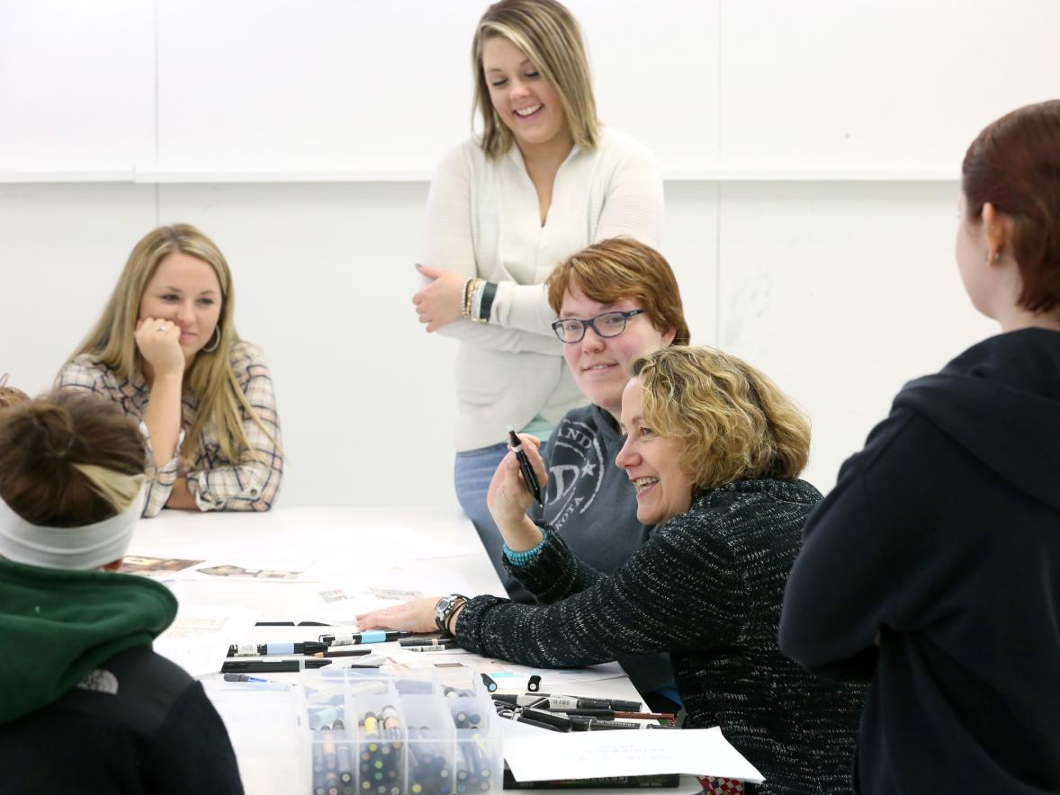 Author and Professor Maureen Mitton, second from right, works with interior design students in a class 
