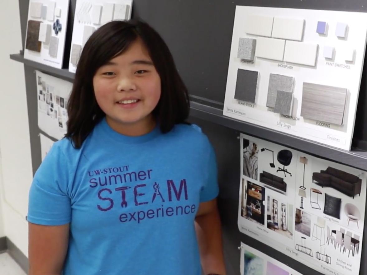 A student displaying their interior design project at the Summer STEAM Camp showcase.