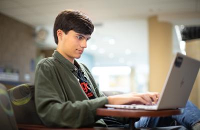 Student sitting in Memorial Student Center on computer