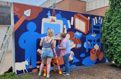Graffiti and Street Art students adding finishing touches to the mural.